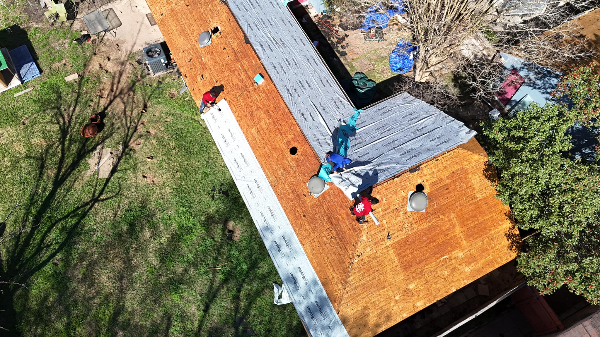 default Roof repair crew working on a residential roof in Dallas, Texas, with new underlayment and materials visible, showcasing ongoing maintenance and restoration efforts.