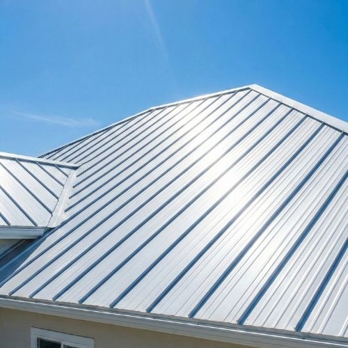 Metal roof with reflective surface under clear blue sky, showcasing durability and energy efficiency for Texas homes.